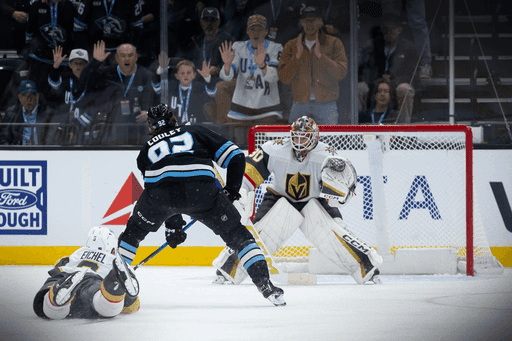 Hockey players contesting a shot on goal